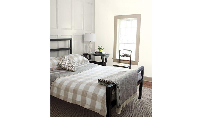 Relaxing bedroom with gray wainscoting behind black bed with gray and white checkered bedding. Relaxing bedroom with gray wainscoting behind black bed with gray and white checkered bedding.