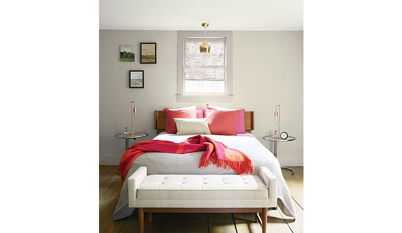 A relaxing bedroom with light gray walls, full size bed with pink pillows and a throw blanket. A relaxing bedroom with light gray walls, full size bed with pink pillows and a throw blanket.