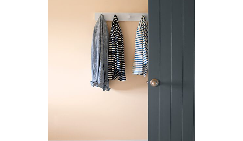 A peach-painted wall with white trim and gray doors. A peach-painted wall with white trim and gray doors.