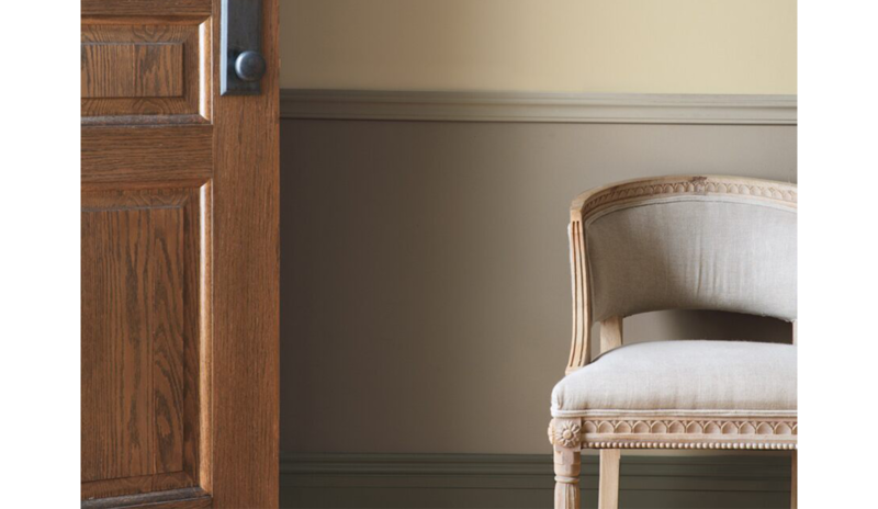 Taupe entryway with wooden door, wainscoting, and beige chair. Taupe entryway with wooden door, wainscoting, and beige chair.