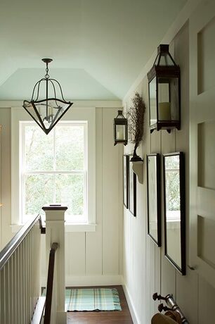 An off-white stairwell with light blue ceiling adorned with a hanging glass light fixture. An off-white stairwell with light blue ceiling adorned with a hanging glass light fixture.