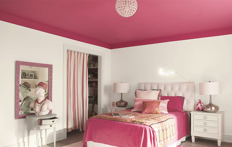 White bedroom walls with a bright pink ceiling and matching pink bedding with tables and lamps. White bedroom walls with a bright pink ceiling and matching pink bedding with tables and lamps.
