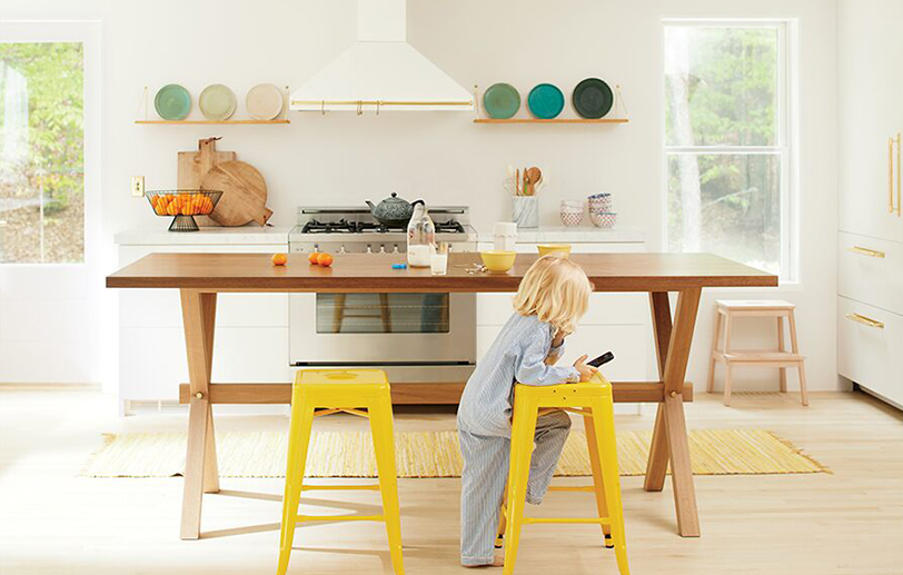 White kitchen with range hood, stove, and open shelves displaying colorful plates. White kitchen with range hood, stove, and open shelves displaying colorful plates.